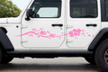 White vehicle with pink floral decals on a road