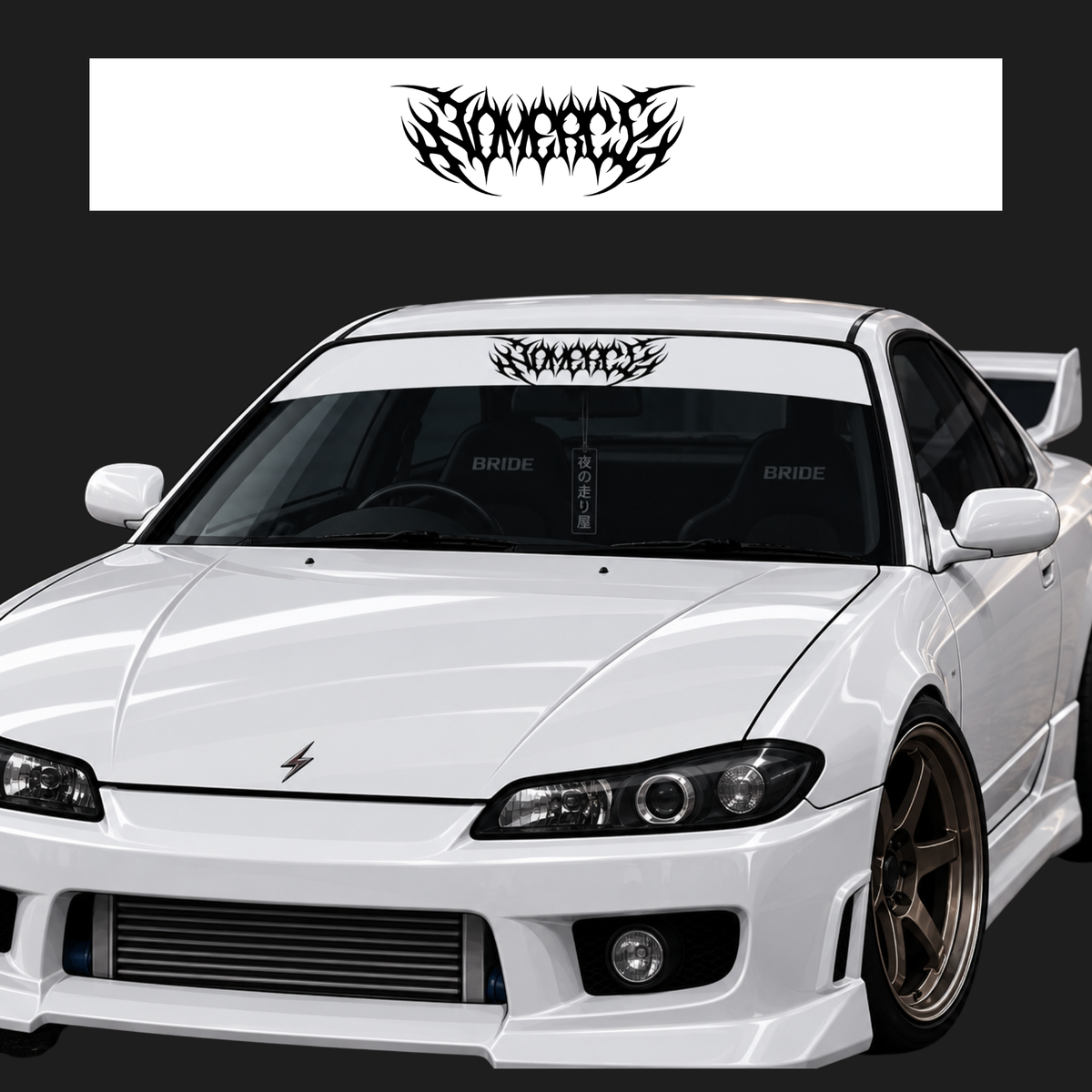 A white modified sports car shown from the front three-quarter angle on a dark studio background, with a black stylized 'Savage' decal displayed on the windshield and a matching decal sheet shown above. The car has a large front splitter, a prominent grille, aftermarket wheels, and 'BRIDE' printed on the seats.