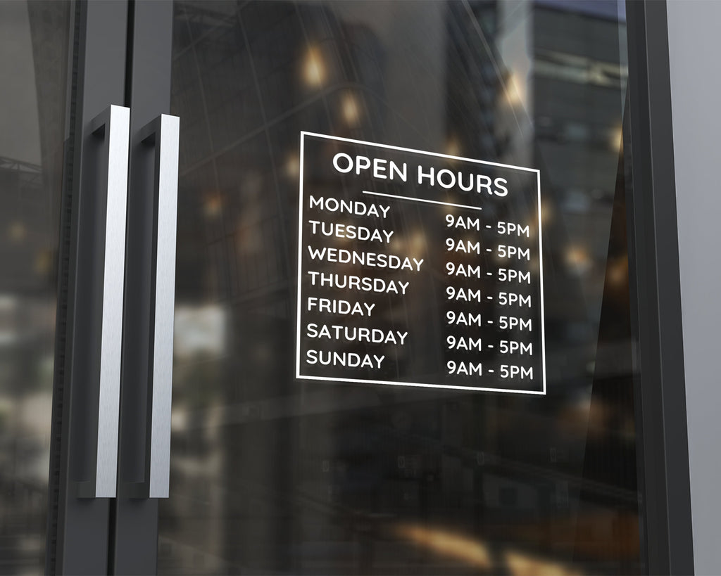 Store hours decal on glass storefront door displaying business hours in white vinyl lettering